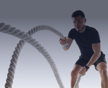 A man is performing battle ropes