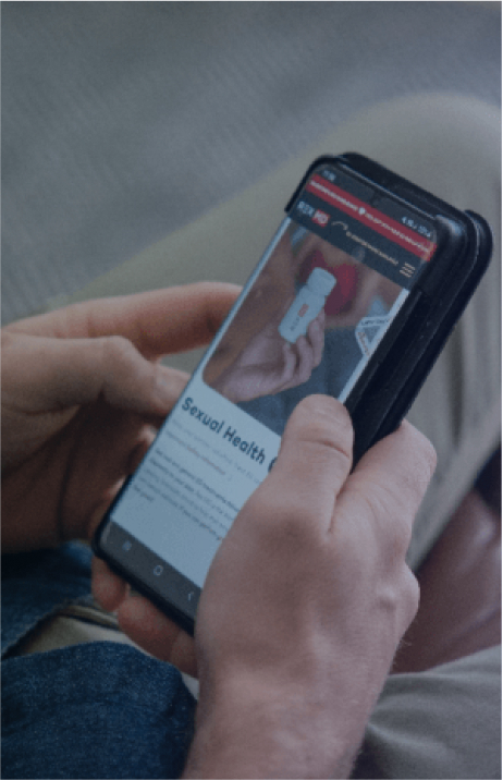 A man is reading about sexual health on Rex MD's website on his phone