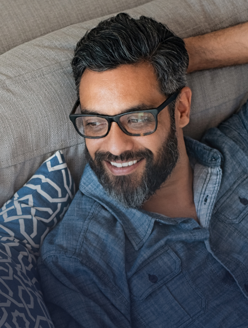 A happy man is relaxing on the couch